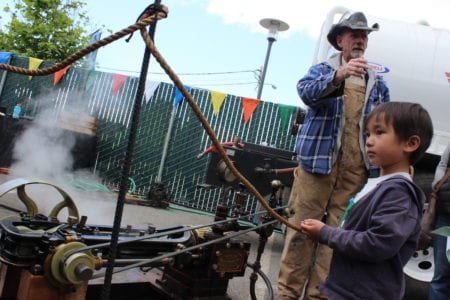 A young observer watches steam-powered kinetic devices at work.